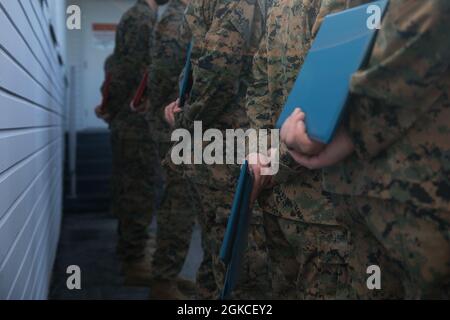 U.S. Marine and Sailors with 1st Marine Division hold their awards during a morning colors ceremony at Marine Corps Base Camp Pendleton, California, March 12, 2021. Marines and Sailors who showed exemplary service while serving with the Division were recognized and awarded during the ceremony. Stock Photo