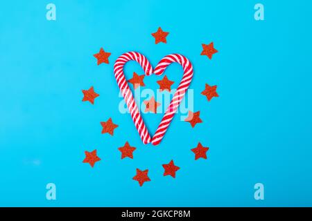 Composition of candy canes with red stars on blue background Stock Photo