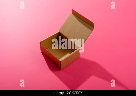 Composition of open empty cardboard gift box on pink background Stock Photo