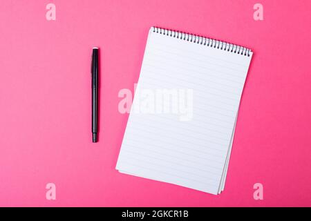 Composition of notebook with copy space and pen on pink background Stock Photo