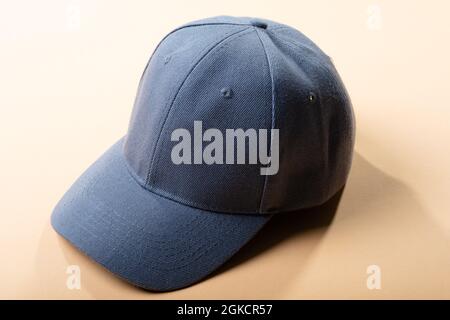 Composition of traditional peaked grey baseball cap on pale brown background Stock Photo
