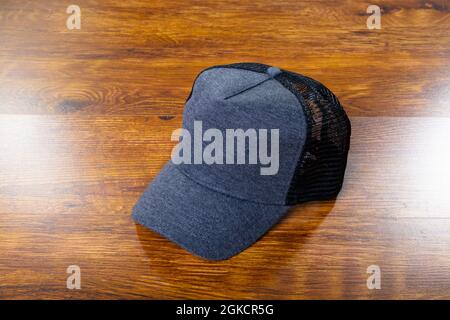 Composition of close up of grey and black baseball cap on wooden background Stock Photo