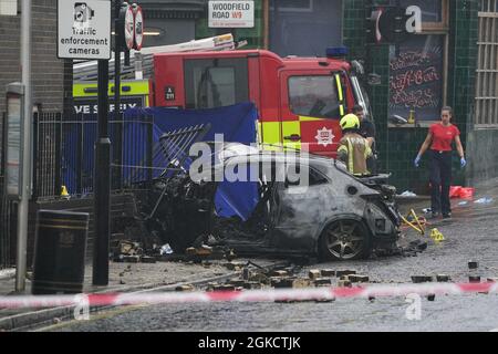 The burnt out shell of a car at the scene on the Great Western Road, Notting Hill, west London, where three people have died after the vehicle collided with a residential block. Picture date: Tuesday September 14, 2021. Stock Photo