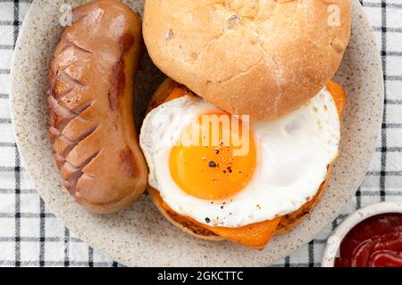 English muffin with egg cheese and sausage on plate, top view Stock Photo