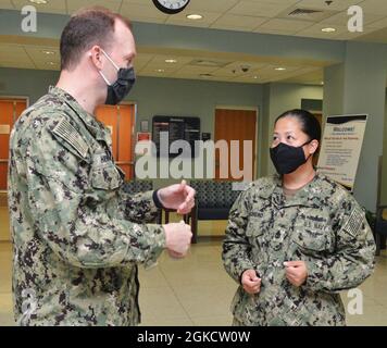 JACKSONVILLE, Fla. (March 18, 2021) - Happy 128th birthday, U.S. Navy Chiefs!  Chief Hospital Corpsman Leslie Cachero, leading chief petty officer at Naval Hospital Jacksonville’s laboratory, discusses enlisted professional development with Cmdr. Jason Henry.  Cachero, a native of San Diego, California, says, “Chief petty officers play a vital role in enforcing standards and are the keepers of Naval heritage and tradition.  As a Chief, I love the fact that we get to know and train each of our sailors to the highest standard, because one day they will be the ones who replace us as senior enlist Stock Photo