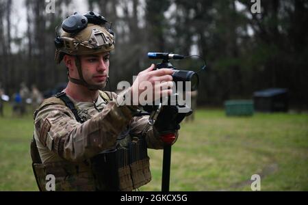 U.S. Air Force Staff Sgt. Jason Allred, a combat videographer assigned to the 1st Combat Camera Squadron, adjust camera settings during Exercise Scorpion Lens at Joint Base Charleston, South Carolina, March 16, 2021. Squadron members are required to perform camera interviews and create nightly video products for grading.  The annual exercise tests Combat Camera team members leadership, documentation skills, and the tactical expertise of the unit’s public affairs, and mission support airmen. Stock Photo