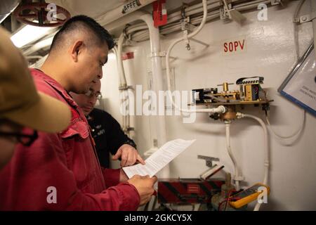 210316-N-WQ732-4005 MEDITERRANEAN SEA (March 16, 2021) Electrician’s Mate 2nd Class Michael Crow, from Keystone Heights, Florida, shows Damage Controlman 3rd Class Kevin Sualibio, from Hemet, California, maintenance for an aqueous film forming foam (AFFF) panel aboard the Ticonderoga-class guided-missile cruiser USS Monterey (CG 61), March 16, 2021.  Monterey is operating with the IKE Carrier Strike Group on a routine deployment in the U.S. Sixth Fleet area of operations in support of U.S. national interests and security in Europe and Africa. Stock Photo
