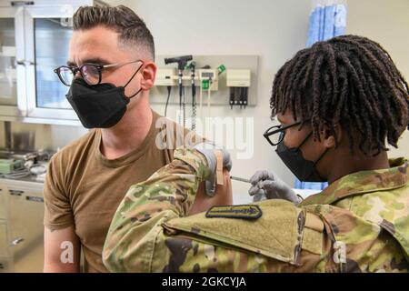 210216-N-ZU848-0208 CHINHAE, Republic of Korea (Mar. 16, 2021) Spc. Nedjie Joseph administers the second dose of COVID-19 vaccine to Lt. j.g. Billy Petkovski at Navy Branch Health Clinic Chinhae. Sailors assigned to Navy Branch Health Clinic Chinhae and Soldiers assigned to the 549th Medical Hospital Center, 65th Medical Brigade administered the second dose of the COVID-19 vaccine, on a completely voluntary basis, to Sailors who were identified as front line personnel by their commands. Stock Photo