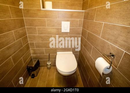 Modern guest WC with large dark bathroom tiles Stock Photo