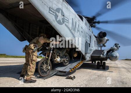 A U.S. Army Soldier with 1st Battalion, 1st Special Forces Group (Airborne), loads a CH-53E Super Stallion with 1st Marine Aircraft Wing during Castaway 21.1 on Ie Shima, Okinawa, Japan, March 17, 2021. The exercise demonstrated the Marine Corps’ ability to integrate with the joint force to seize and defend key maritime terrain, provide low-signature sustainment, and execute long-range precision fires in support of naval operations from an expeditionary advanced base. Stock Photo