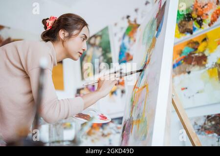female artist working on her painting in studio Stock Photo