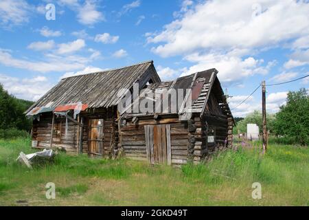 Kola peninsula, Russia - July 10, 2021: Old destroyed abandoned wooden country building in summer day Stock Photo