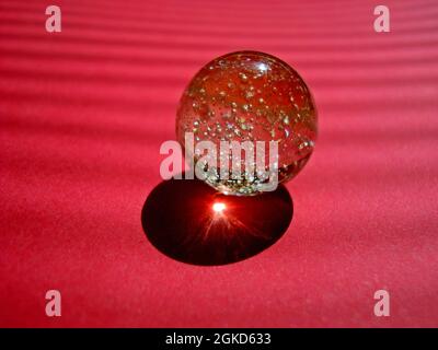 Marble ball on red background Stock Photo