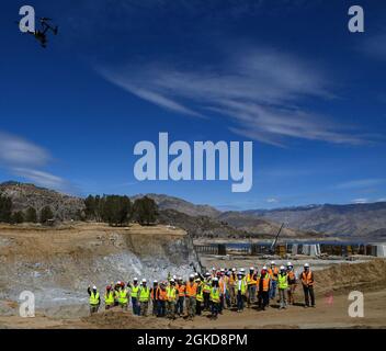 Employees and service members from the U.S. Army Corps of Engineers wave to a drone during filming of a group video in front of the unfinished labyrinth weir at the Isabella Dam Safety Modification Project in Lake Isabella, California March 18, 2021. Maj Gen. William Graham, USACE deputy commander of civil and emergency operations, and Brig. Gen. Paul Owen, commander of the USACE South Pacific Division, made an official visit to the project to receive a briefing and tour the construction site. District employees gave the two generals a tour of the dam’s many features, including the labyrinth w Stock Photo