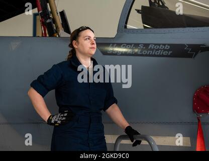 Oregon Air National Guard Staff Sgt. Aimee Lonidier is a Crew Chief assigned to the 142nd Wing, Portland Air National Guard Base, Ore., pauses for a photo with her F-15 Eagle, March 18, 2021. Stock Photo