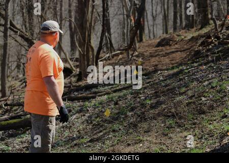 Army civilian Eric Schweighauser, safety manager, 1st Theater Sustainment Command, shows where he has left off on the construction of a mountain bike trail at Buttermilk Falls in Brandenburg, Kentucky, March 20, 2021. The yellow flags mark the outline of the new trail. Stock Photo