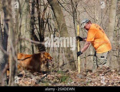 Army civilian Eric Schweighauser, safety manager, 1st Theater Sustainment Command, prepares a  trail with his dog Bailey at Buttermilk Falls in Brandenburg, Kentucky, March 20, 2021. Schweighauser is a founding member of Kentucky Mountain Bike Association, Lincoln Trails and together they help develop and maintain mountain bike trails in the local area. Stock Photo