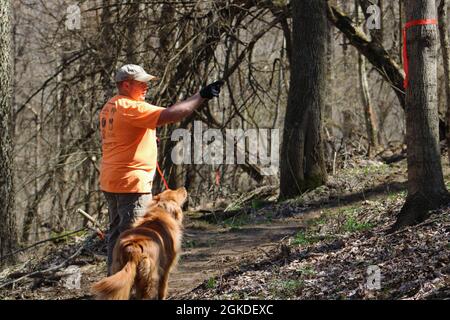 Army civilian Eric Schweighauser, safety manager, 1st Theater Sustainment Command, points to an inward facing trail marker located on a tree at Buttermilk Falls in Brandenburg, Kentucky, March 20, 2021. The trail markers located on the tree face inward so that volunteers know what area to clear on the trail. Stock Photo