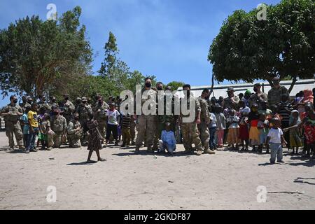 Task Force Bayonet Soldiers assigned to U.S. Army Alpha Company, 2nd Battalion, 135th Infantry Regiment. and a U.S. Airman assigned to the 475th Expeditionary Air Base Squadron at Camp Simba, Kenya, pose with Magogoni villagers in Lamu, Kenya, March 20, 2021 The Soldiers collected donations from loved ones back in the U.S. from Nov. 2020- March 2021 as part of humanitarian support to the region. Stock Photo