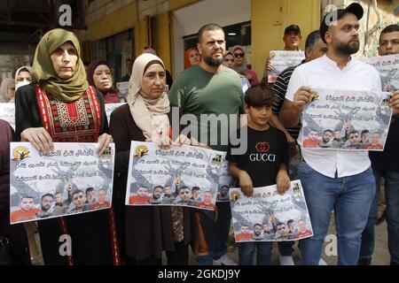 Jenin, Palestine. 14th Sep, 2021. Palestinians seen holding portraits showing prisoners, Zakaria al-Zubaidi and the four prisoners who escaped from Jalameh prison during the demonstration in solidarity with Palestinian prisoners held in Israeli prisons, outside the offices of the International Committee of the Red Cross in the city of Jenbin. (Photo by Nasser Ishtayeh/SOPA Images/Sipa USA) Credit: Sipa USA/Alamy Live News Stock Photo