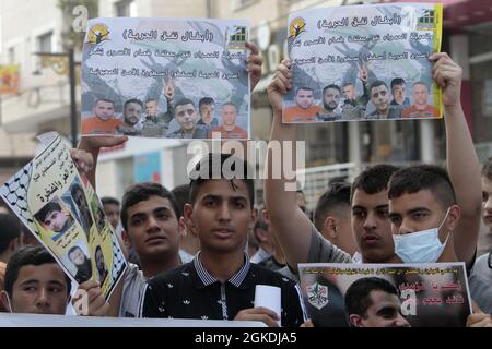 Jenin, Palestine. 14th Sep, 2021. Palestinians seen holding portraits showing prisoners, Zakaria al-Zubaidi and the four prisoners who escaped from Jalameh prison during the demonstration in solidarity with Palestinian prisoners held in Israeli prisons, outside the offices of the International Committee of the Red Cross in the city of Jenbin. (Photo by Nasser Ishtayeh/SOPA Images/Sipa USA) Credit: Sipa USA/Alamy Live News Stock Photo