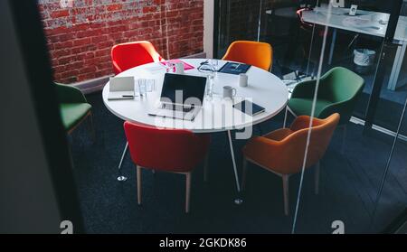 Empty meeting room in a modern workplace. Still life shot of an office table with various gadgets placed on it. Stock Photo