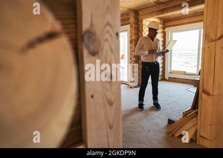 Designing engineer standing on construction site with laptop Stock Photo