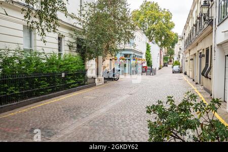 Cobbled mews and backstreet pub, London. A typical mews street in South Kensington with a traditional public house on the corner of a leafy street. Stock Photo