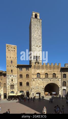 SAN GIMIGNANO, ITALY - Aug 14, 2021: A vertical shot of tourists walking around Towers of San Gimignano in Tuscany, Italy Stock Photo