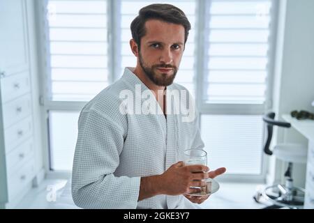 Patient in a waffle weave bathrobe holding a non-alcoholic beverage Stock Photo