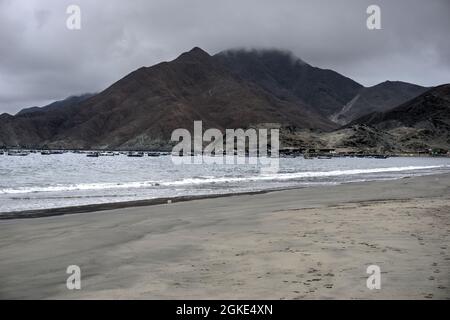 El Dorado, Peru - July 30, 2021: Small moored fishing boats with beach in foreground and mountains in background Stock Photo