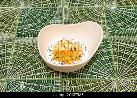 Quinoa salad with aubergine, carrot and poppy seeds on a yogurt background in a nice white bowl Stock Photo