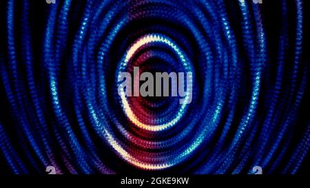 Abstract blue and red shiny particles forming rings and effect of deep tunnel. Motion. Colorful dots forming circles on black background Stock Photo