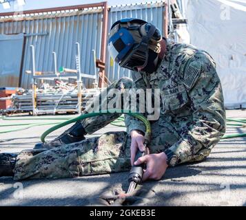 210329-N-SY758-1008 PORTSMOUTH, Va. (March 29, 2021) Aviation Maintenance Administrationman Airman Jacob Salters, from Kimberly, Alabama, uses a needle gun to clean a padeye on the flight deck aboard the aircraft carrier USS George H. W. Bush (CVN 77). GHWB is currently in Norfolk Naval Shipyard for its Docking Planned Incremental Availability. Stock Photo