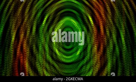 Abstract dotted green, yellow, and red ovals spreading on black background. Motion. Colorful particles becoming transparent and disappear Stock Photo