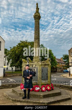 A piper plays bagpipes at war memorial commemorates St Valery Day when Scottish soldiers were captured in World War II, North Berwick, Scotland, UK Stock Photo