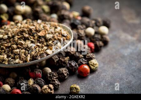 Mixed peppercorns on the rustic background. Selective focus. Shallow depth of field. Stock Photo