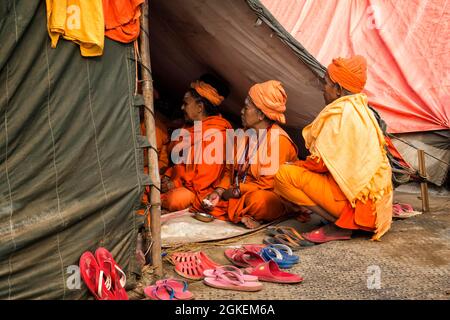 Sadhvi in orange and red saree during Allahabad Kumbh Mela, the largest religious gathering in the world, Uttar Pradesh, India Stock Photo