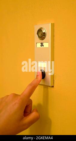 Hand of a woman who is ringing a doorbell Stock Photo