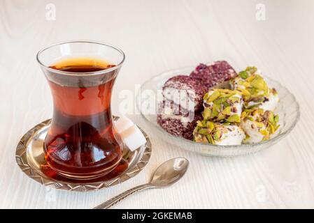 Traditional Turkish tea in a glass with sweets and a spoon Stock Photo
