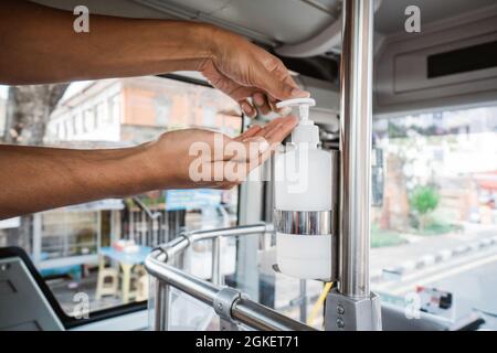 hands wash with an automatic sanitizer dispenser in public transport Stock Photo