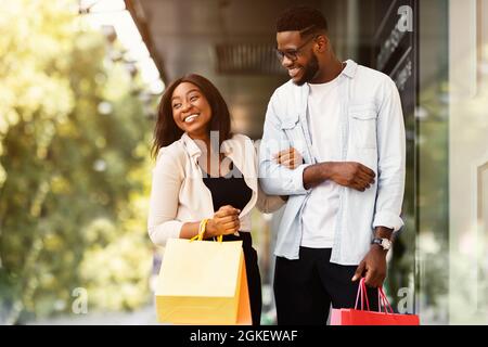 Portrait of black couple walking with shopping bags Stock Photo