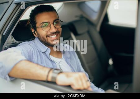 Young indian guy listening to music in car Stock Photo