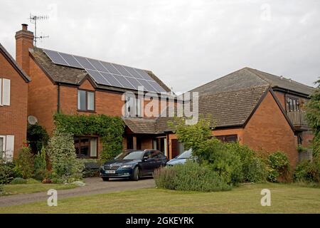 Modern redbrick detached house with solar PV panels on tiled roof Bidford on Avon Warwickshire UK Stock Photo