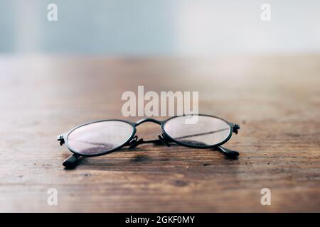 Bad eye sight or myopic - Reading glasses on wooden table close-up soft focus Stock Photo