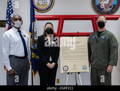 KADENA, Japan (Apr. 5, 2021) Marine Corps Community Services Okinawa  personal financial management specialists Anthony Green and Brianna Rico stand with Capt. Scott Hardy, Commander, Fleet Activities Okinawa commanding officer, after he signed the Military Saves Month proclamation onboard CFAO at Kadena Air Base, Okinawa, Japan Apr. 5, 2021. The annual Military Saves Month campaign is dedicated to helping service members and their families save money, reduce debt, and build wealth. Stock Photo