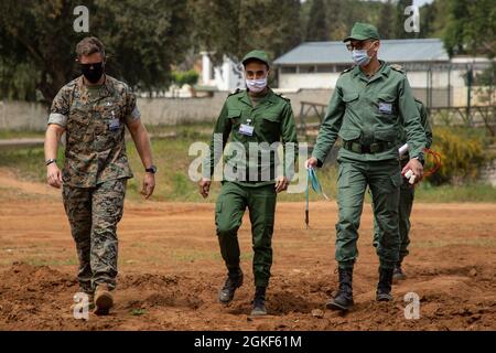 A U.S. Marine and members of the Royal Moroccan Armed Forces carry demolition equipment during a practical application scenario during an Explosive Ordnance Disposal (EOD) class near Kenitra, Morocco, April 6, 2021. Marines, Sailors, and members of the Utah National Guard are participating in Humanitarian Mine Action, Explosive Ordnance Disposal Morocco 2021 where U.S. EOD technicians are supervising level two EOD validation of Royal Moroccan Armed Forces (FAR) soldiers to continue efforts to create an EOD capability inside the FAR. Stock Photo