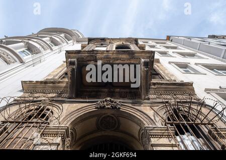 Taksim, Istanbul, Turkey - 03.12.2021: low angle view of an old ruined historical building and new modern ones between them under blue sky Stock Photo