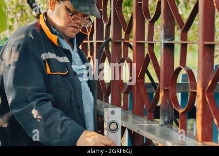 Portrait of concentrated mature builder placing spirit level. Handyman working with building level indoors. Professional tools to check measure level Stock Photo