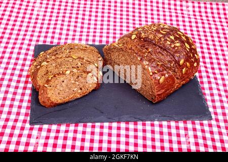 Freshly baked Pumpernickel boule rye bread on a slate serving platter Stock Photo